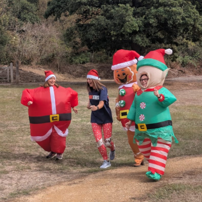 Runners in Christmas costumes jogging along a country path