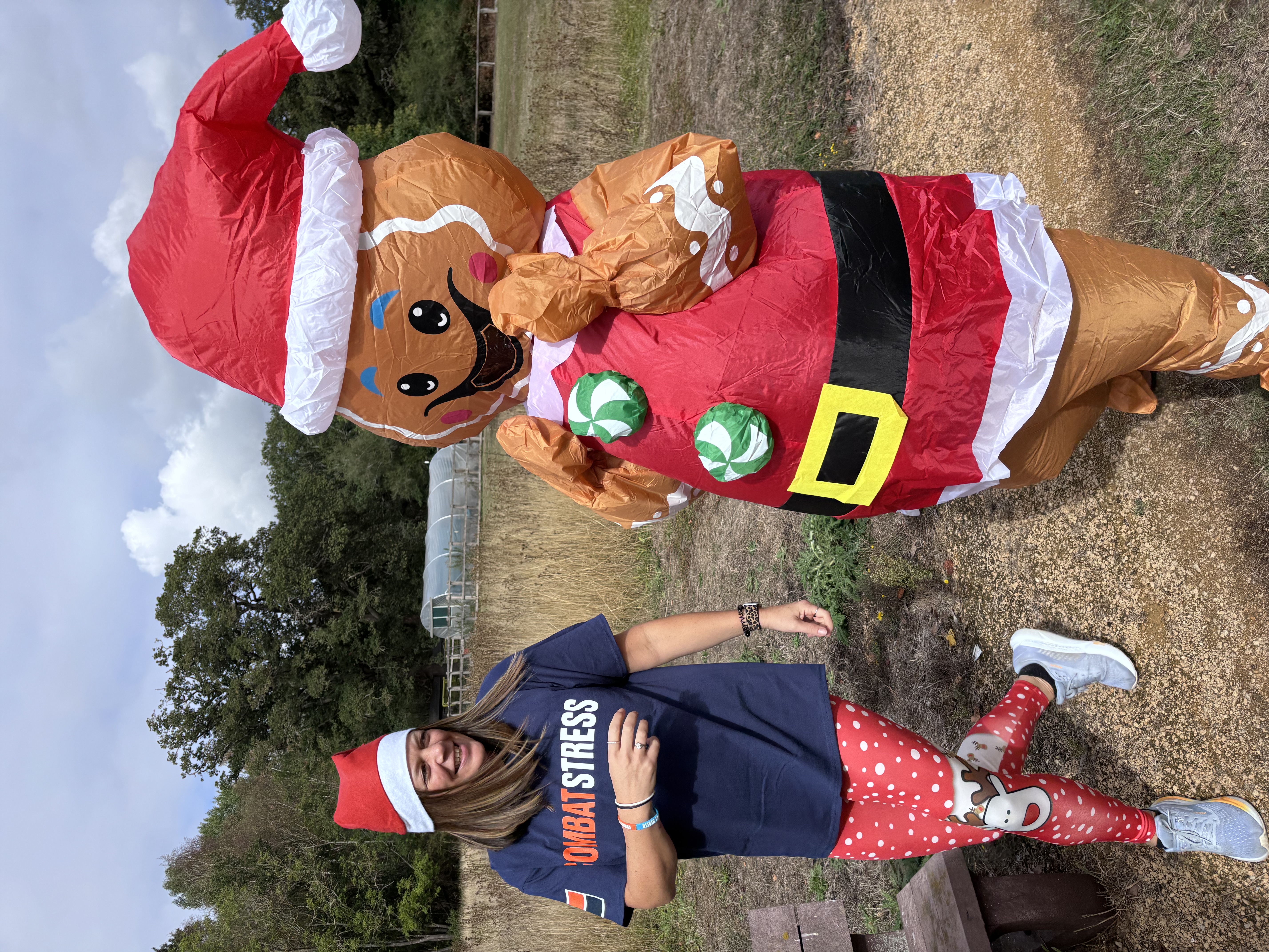 A Combat Stress supporter in a Santa hat beside an inflatable gingerbread costume